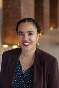 A woman smiling at the camera wearing a black jacket